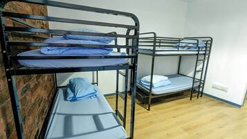 A bunk bed room with two bunk beds, each with blue bedding.