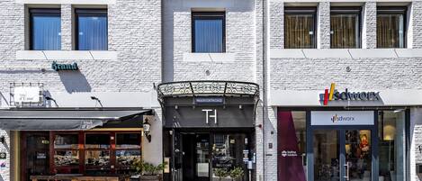 A theater hotel with a black sign, a brand store, and a visible entrance.