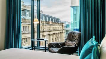 Habitación de hotel con un ventanal que ofrece vistas a edificios históricos.