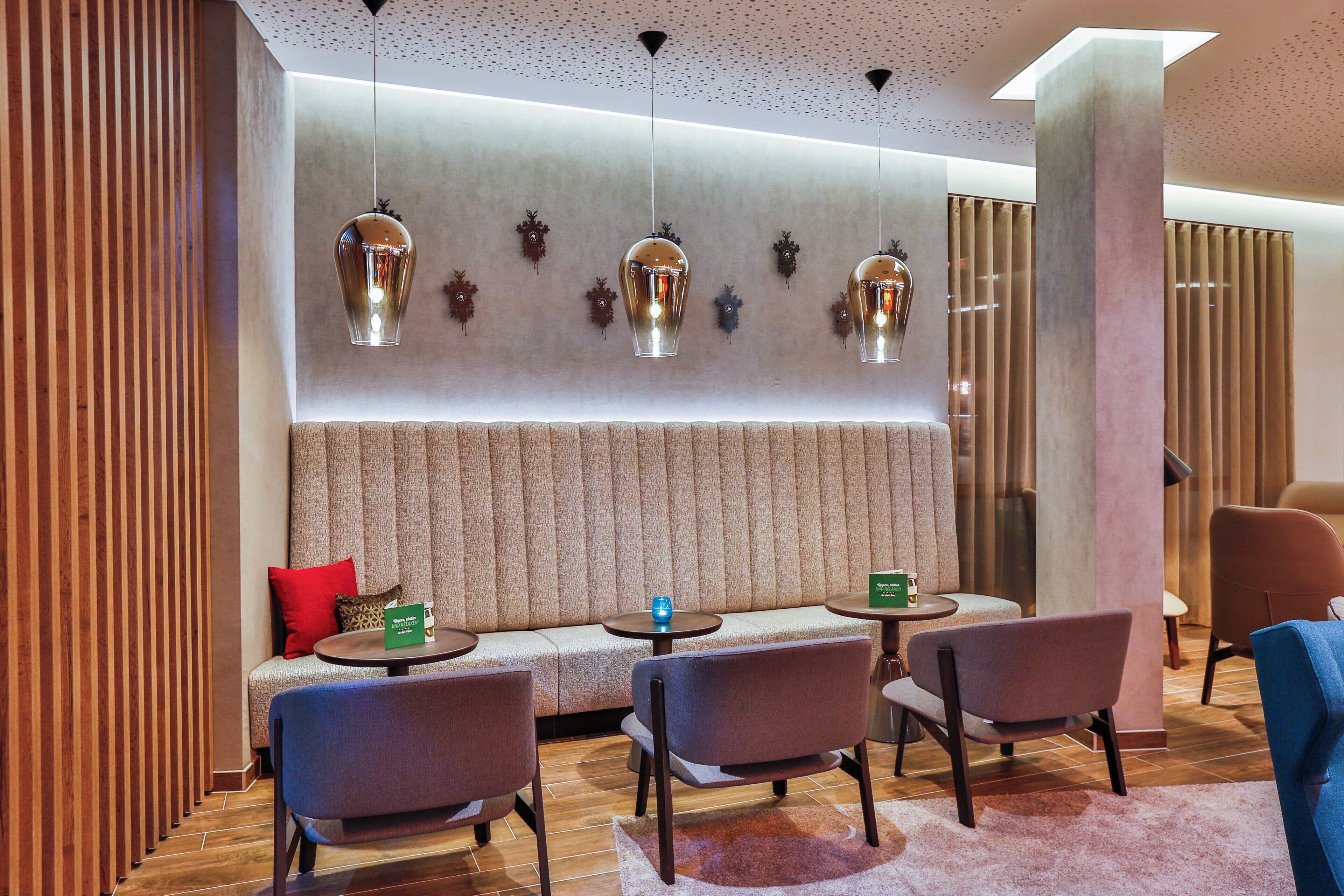 A modern interior with a seating area, tables, and decorative wall lights.