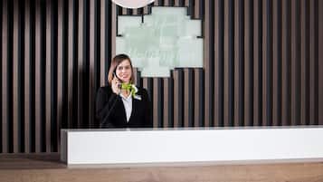 A hotel reception desk with a modern design, a nameplate, and a vertical striped wall.
