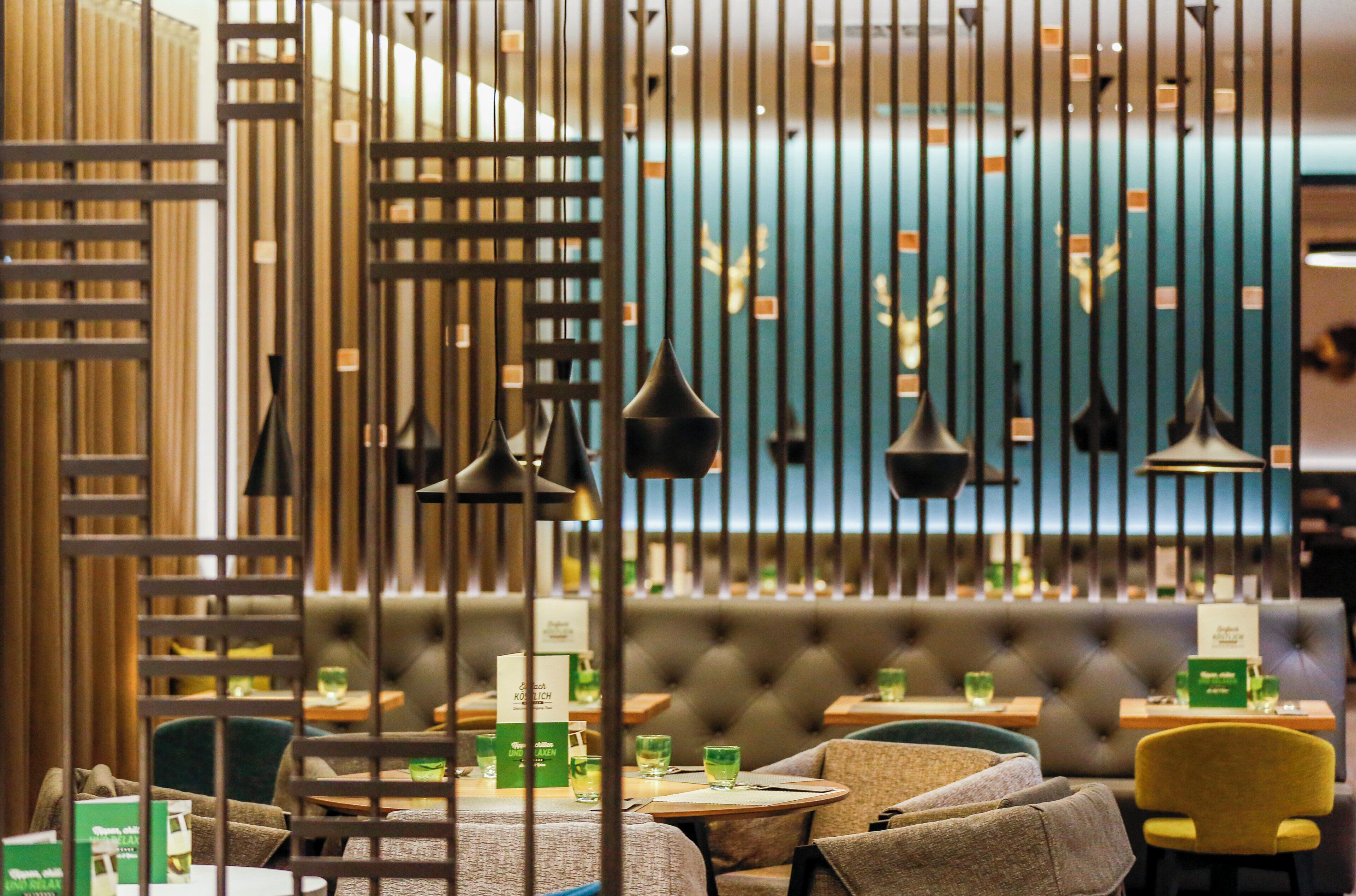 A restaurant interior with a bar area, seating, and a blue wall with decorative elements.