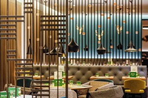 A restaurant interior with a bar area, seating, and a blue wall with decorative elements.