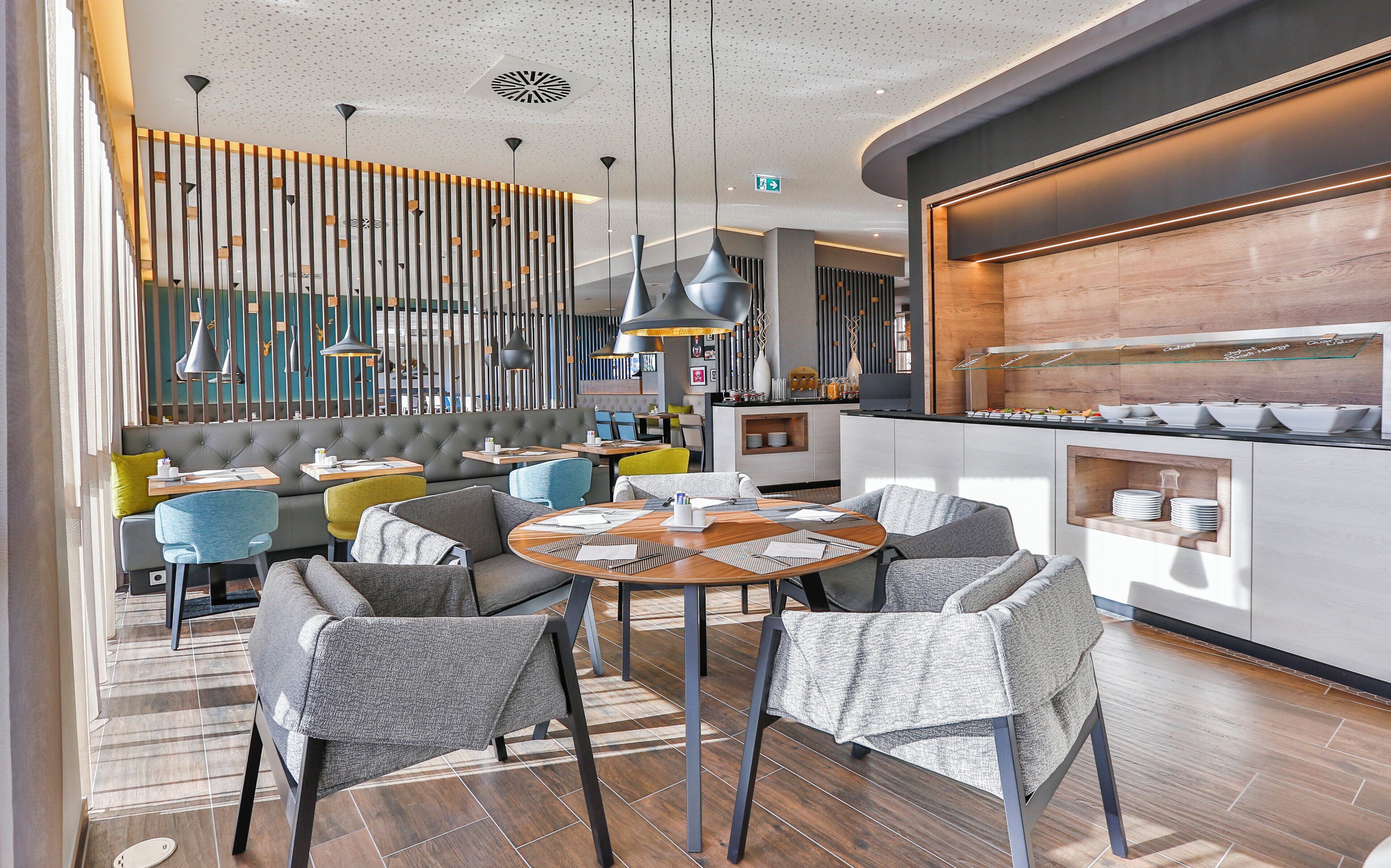 Un interior de restaurante moderno con una zona de bar, arreglos de asientos y un mostrador tipo bufé.