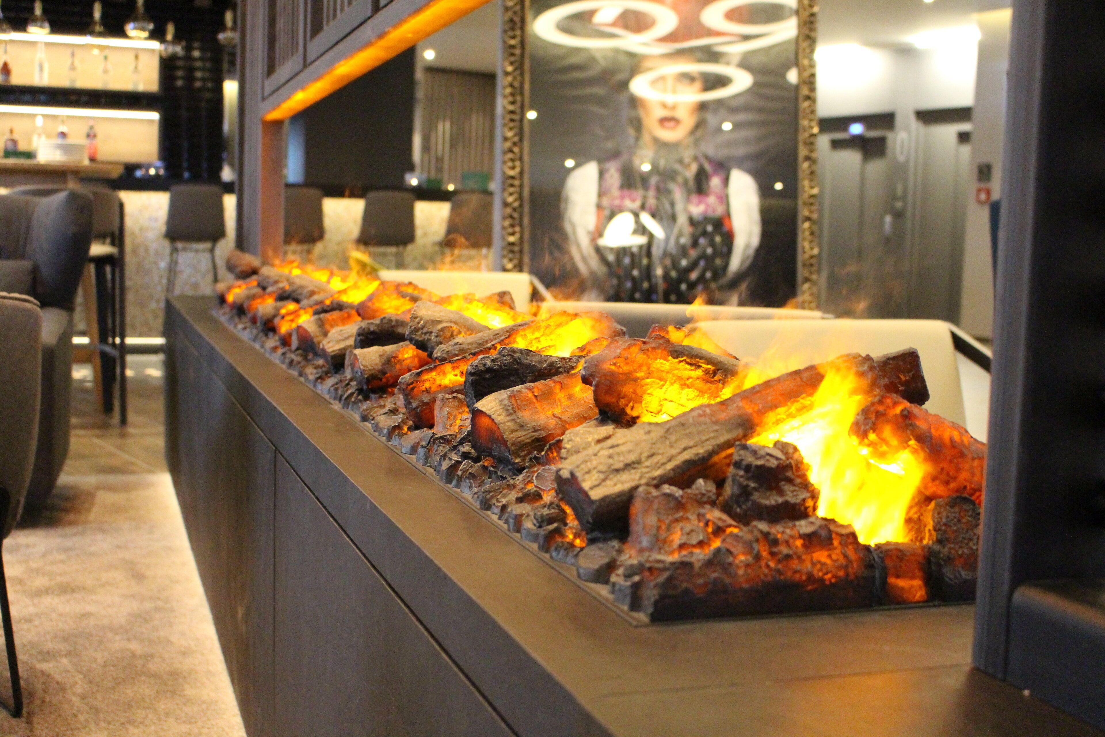 Una zona de bar con una barra larga y una chimenea.