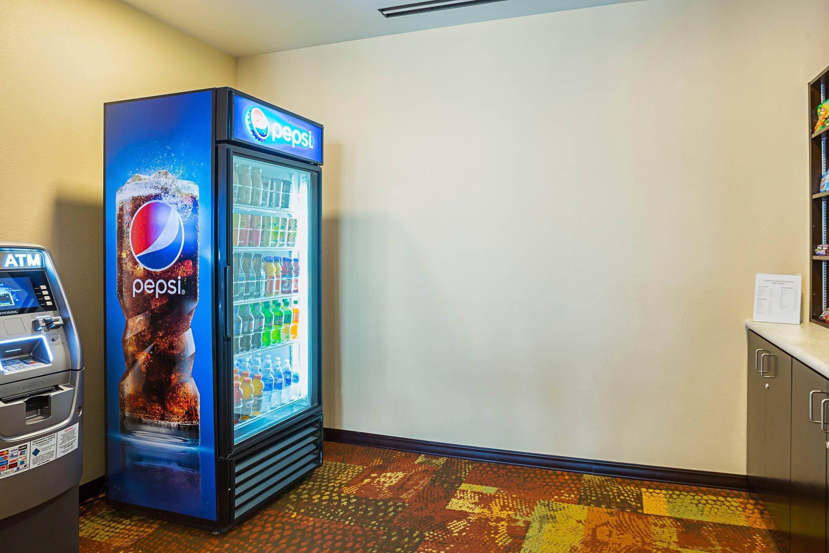Pepsi-juomajääkaappi ja pankkiautomaatti hotellin aulassa.