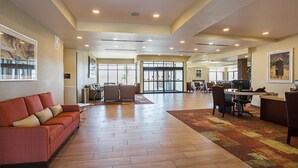 A spacious lobby with a red sofa, a patterned rug, and a reception desk with computers. - The Hotel at Sunland Park Casino El Paso, an Ascend Collection Hotel (Sunland Park)