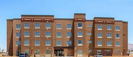 A multi-story hotel with a symmetrical facade, large windows, and a central entrance with a covered area.