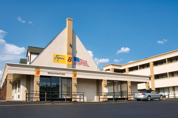 A hotel with a registration area, a parking lot, and a flag.