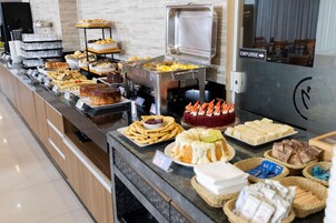 Buffet com diversos alimentos e placa indicando a direção para o EMPURRER.