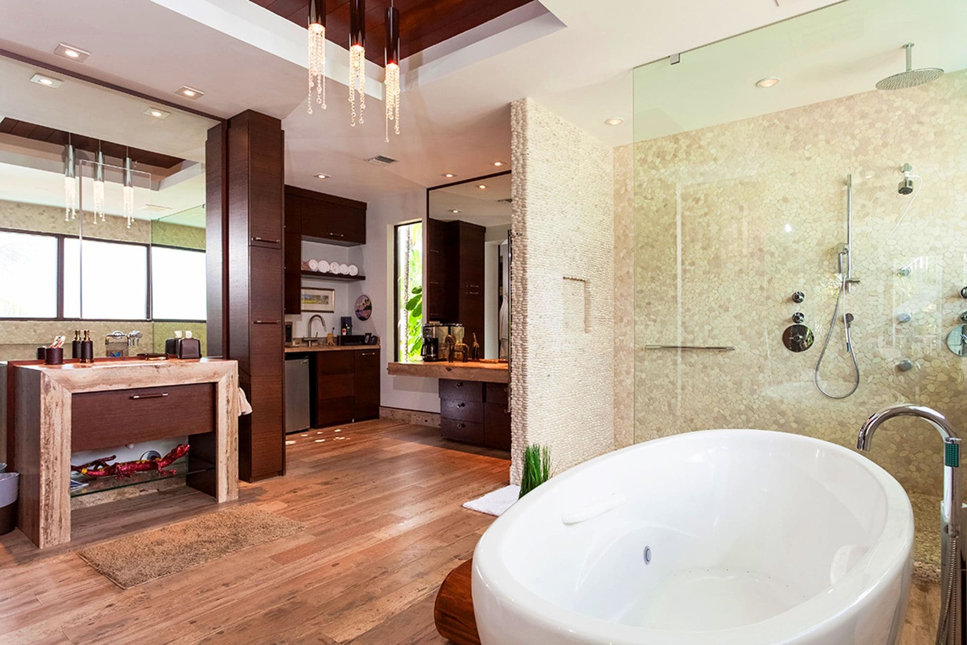 Un bagno moderno con una vasca freestanding ampia, una cabina doccia in vetro e un mobile bagno in legno con lavandino e specchio.