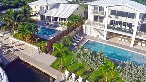 A resort with a large swimming pool, lounge chairs, and a boat dock. - 6 Bedroom Homes in Miami by TMG (Miami)
