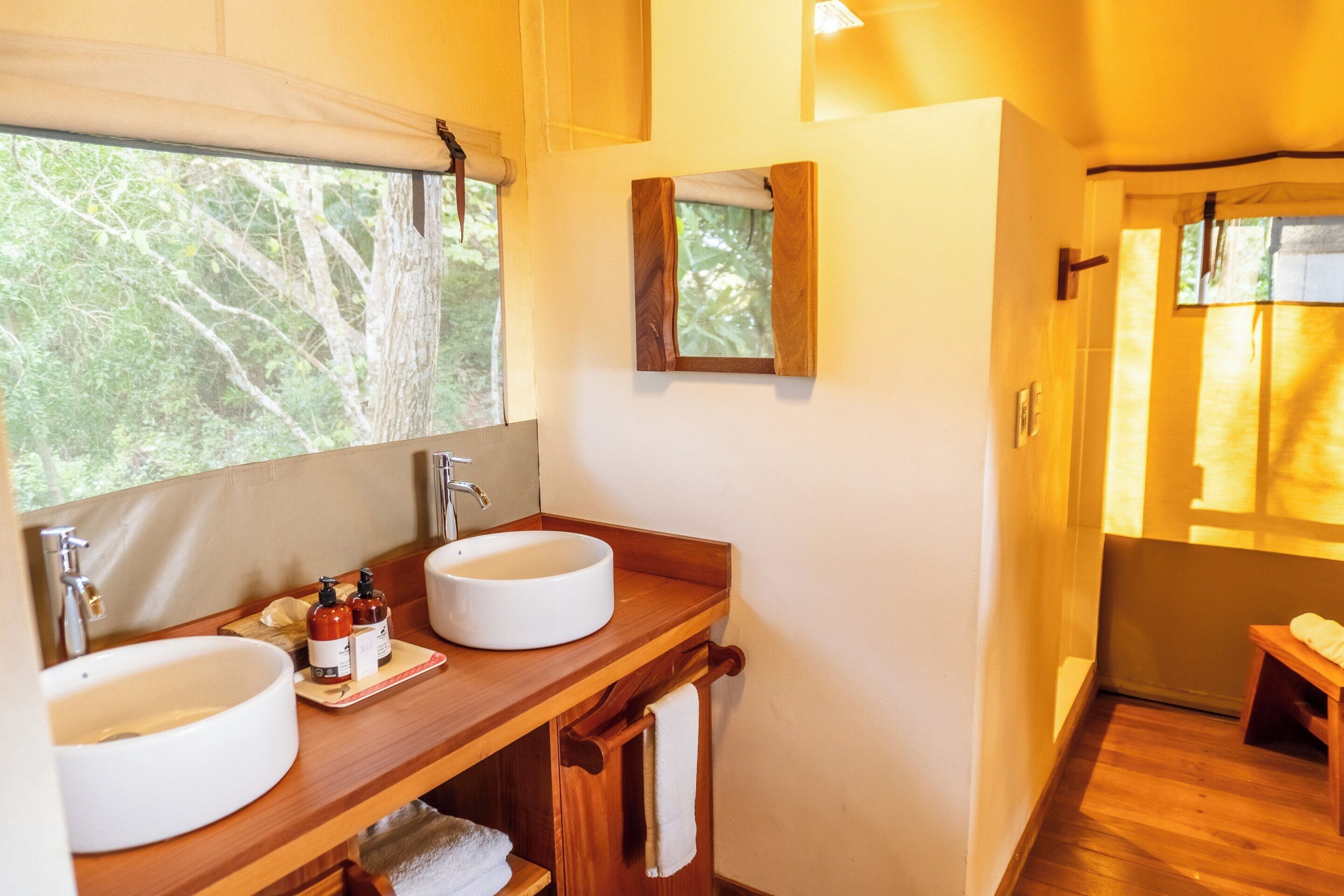 A bathroom with two sinks, wooden vanity, and a mirror.