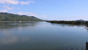 A calm lake with a forested mountain in the background.