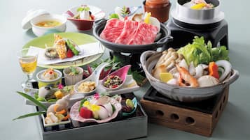 A variety of Japanese dishes including sushi, sashimi, and a hot pot setup.