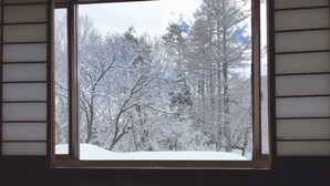 A window with a view of a snow-covered forest. - Hakuba Landmark Happo Lodge (Hakuba)
