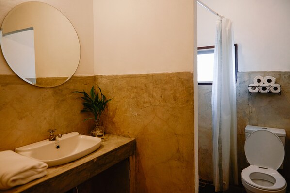 A bathroom with a sink, mirror, and toilet. - Nanan House Hostel (Chiang Mai)