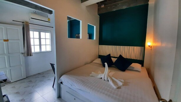 Un dormitorio con cama, puerta y ventana.