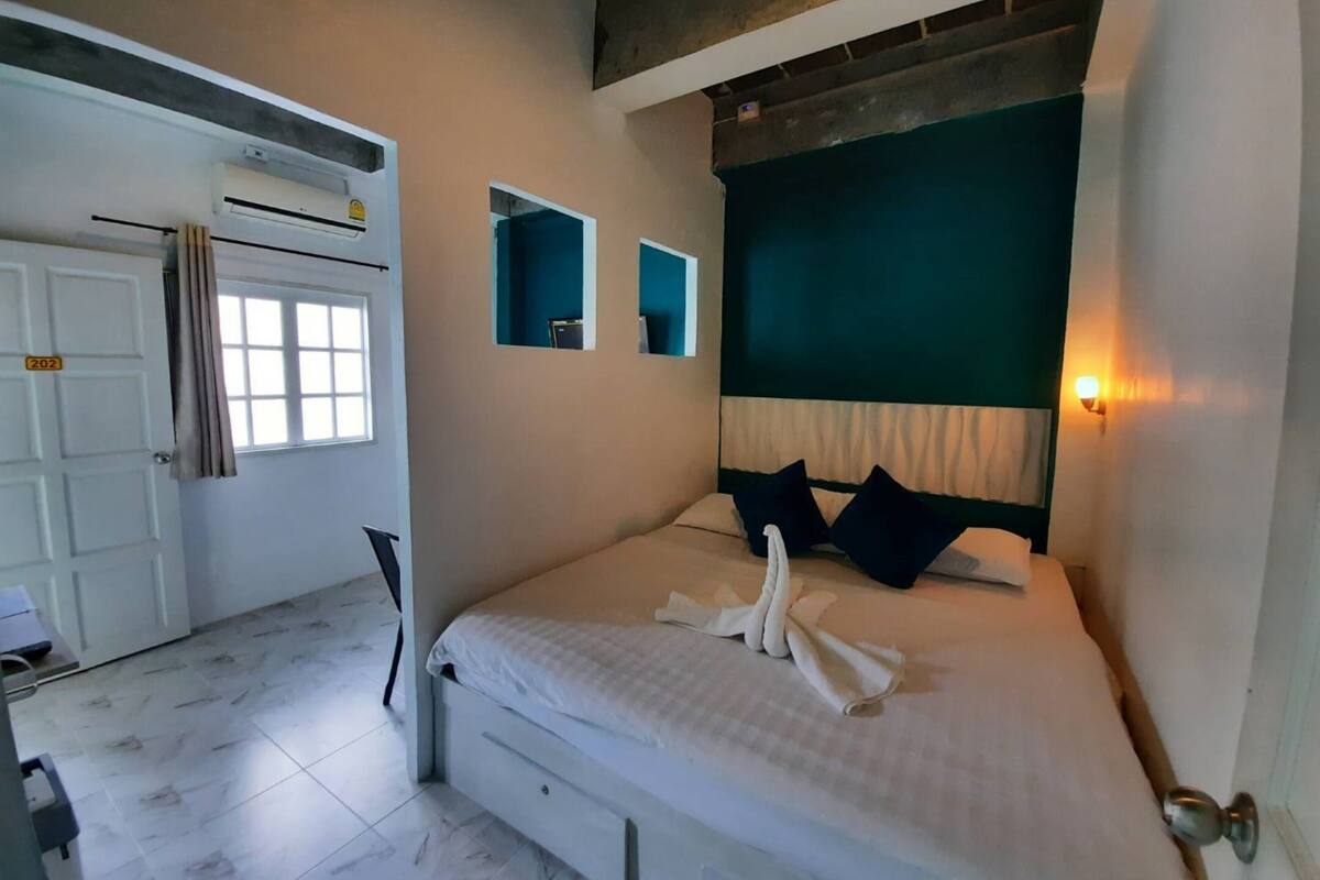 Un dormitorio con cama, puerta y ventana.