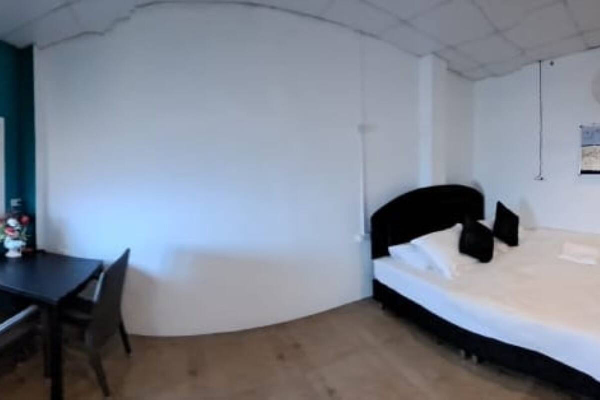 Una habitación con cama, escritorio y silla.