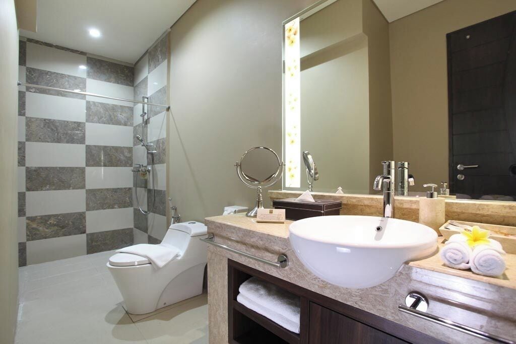 A modern bathroom with a shower, toilet, sink, and vanity.