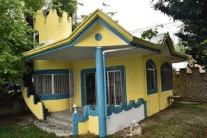 A yellow building with blue trim and a small porch.