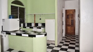 A kitchen with green walls, a checkered floor, and a wooden door. - King Arthur's Place (Alcoy)