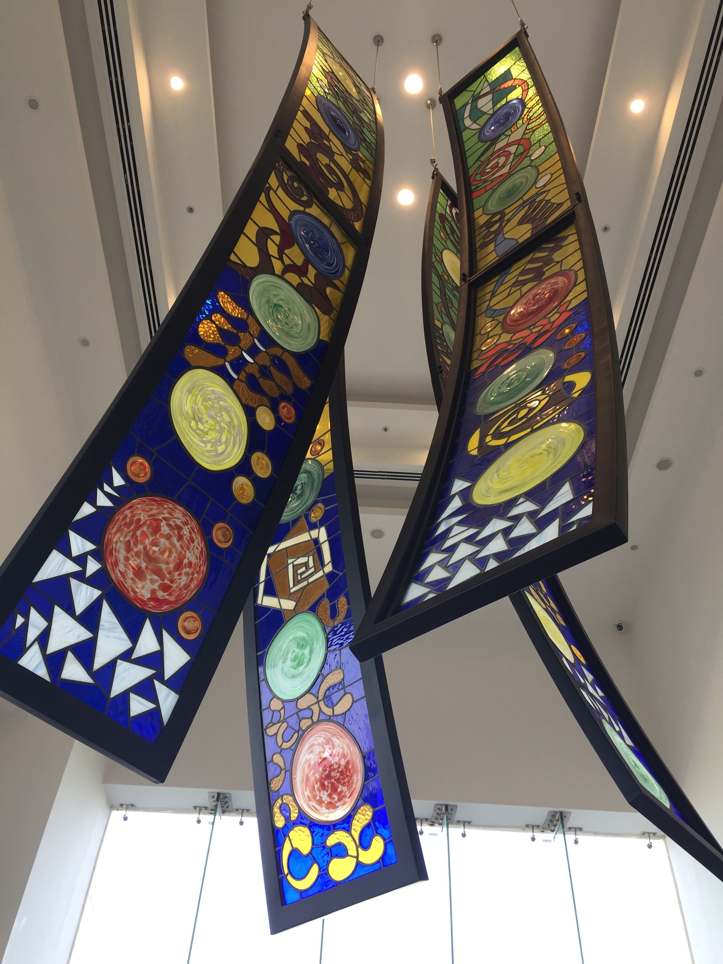 A ceiling with three large, colorful stained glass panels.