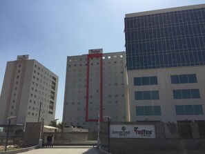 A hotel complex with multiple buildings, including a prominent red vertical structure. - Red Fox by Lemon Tree Hotels, Sector 60, Gurugram (Sohna)