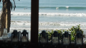 A beach view with palm trees, ocean waves, and hanging light fixtures. - The Seascape (Matara)