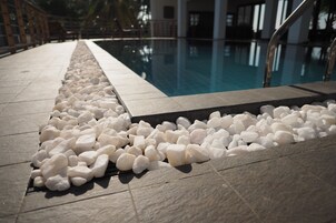 Una piscina al aire libre, sillones reclinables de piscina