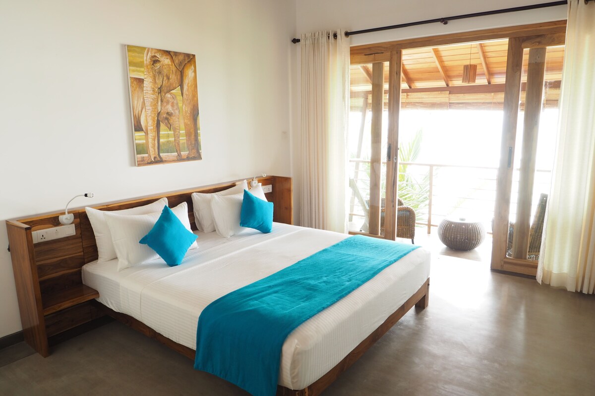Un dormitorio con cama de madera, ropa de cama blanca y almohada decorativa azul.