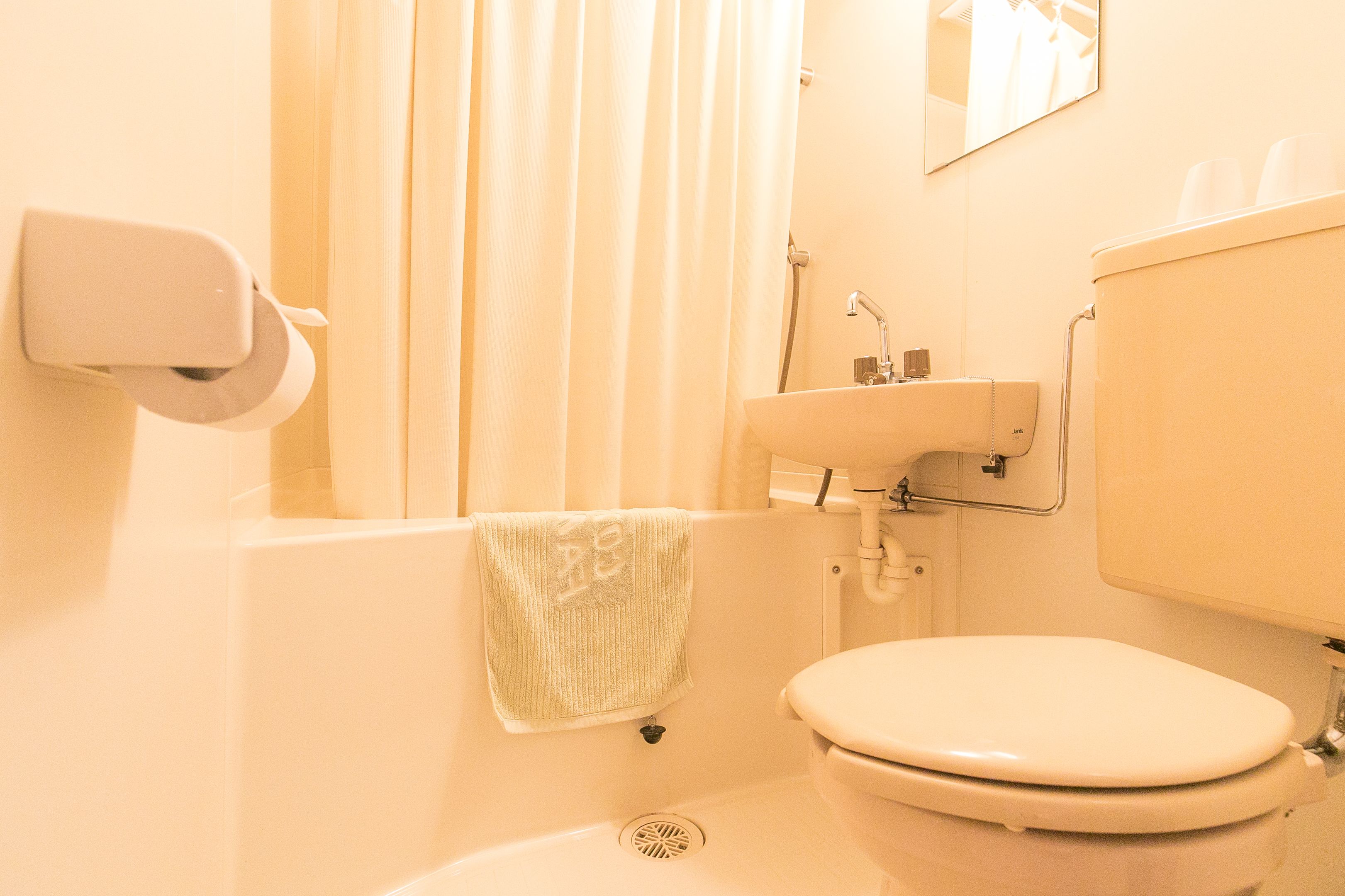 A bathroom with a toilet, sink, and shower.