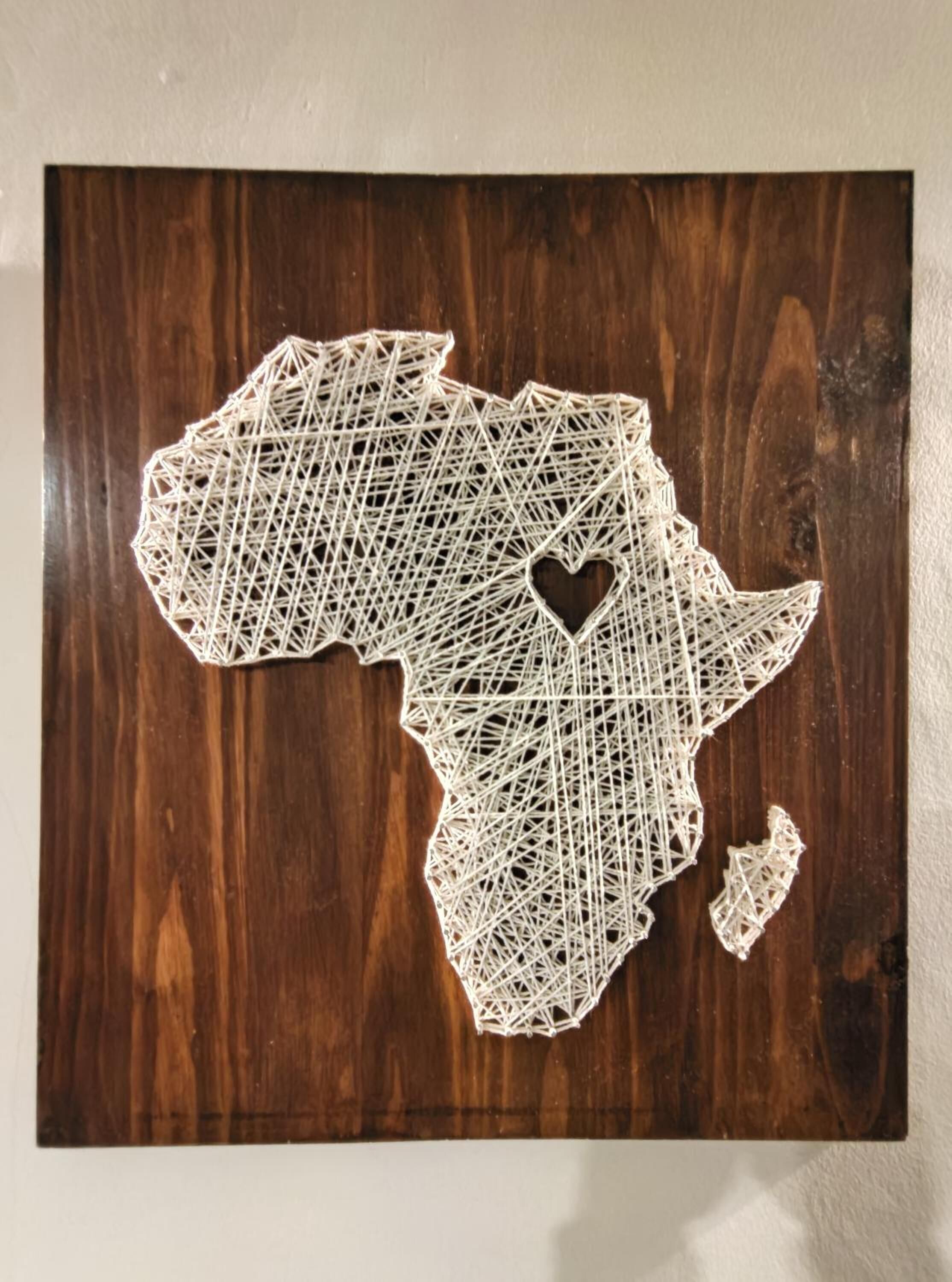 A wooden map of Africa with a heart shape in the center.