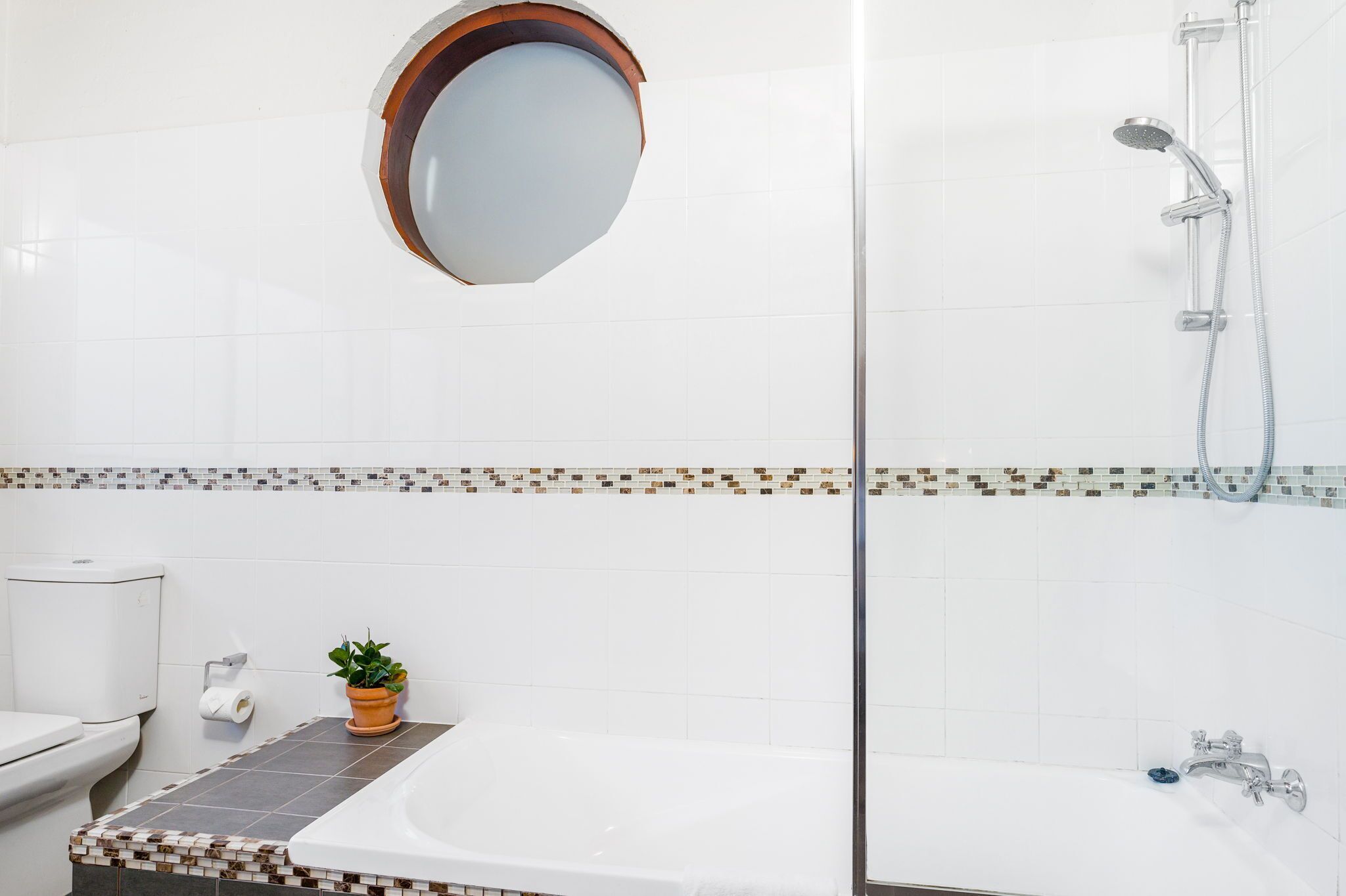 Un baño con ducha, inodoro y lavabo.