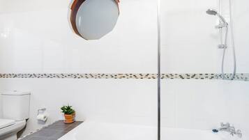 Un baño con ducha, inodoro y lavabo.