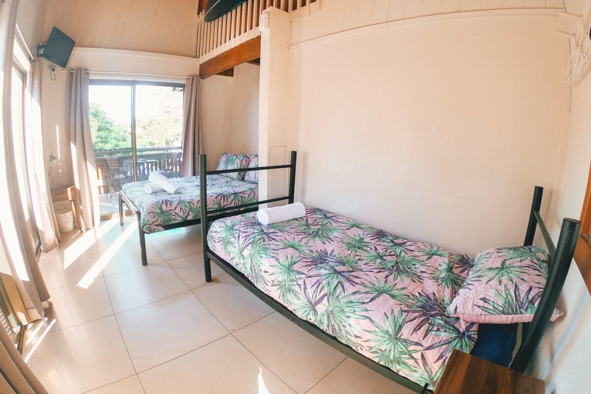 Ein Zimmer mit zwei Etagenbetten, einem Balkon und einem großen Fenster.
