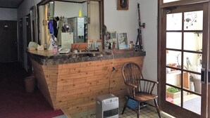 Una habitación con mostrador de madera, una silla, un espejo grande y una ventana.