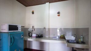A compact kitchen with a microwave, a teal refrigerator, and a sink. - Happy House (Koh Samui)