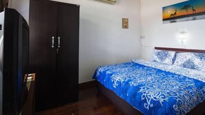 A bedroom with a bed, a wardrobe, an air conditioner, and a wall-mounted artwork. - Happy House (Koh Samui)