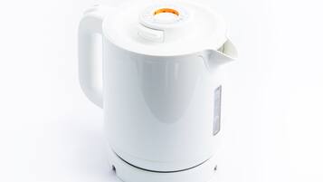 Ein weißer Wasserkocher mit Henkel und Ausguss.