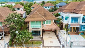 Zona residencial con varias casas, un acceso con portones y vistas a montañas distantes.