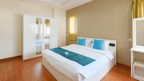 Habitación de hotel con cama, armario, mesita de noche y lámpara de pared.