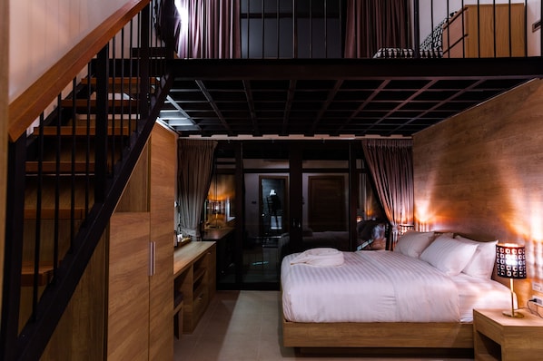 A bedroom with a wooden bed, a nightstand, a desk, and a staircase. - 15 Palms Beach Resort (Ko Chang)