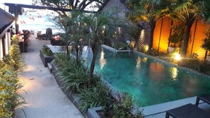 Una piscina al aire libre, sillones reclinables de piscina