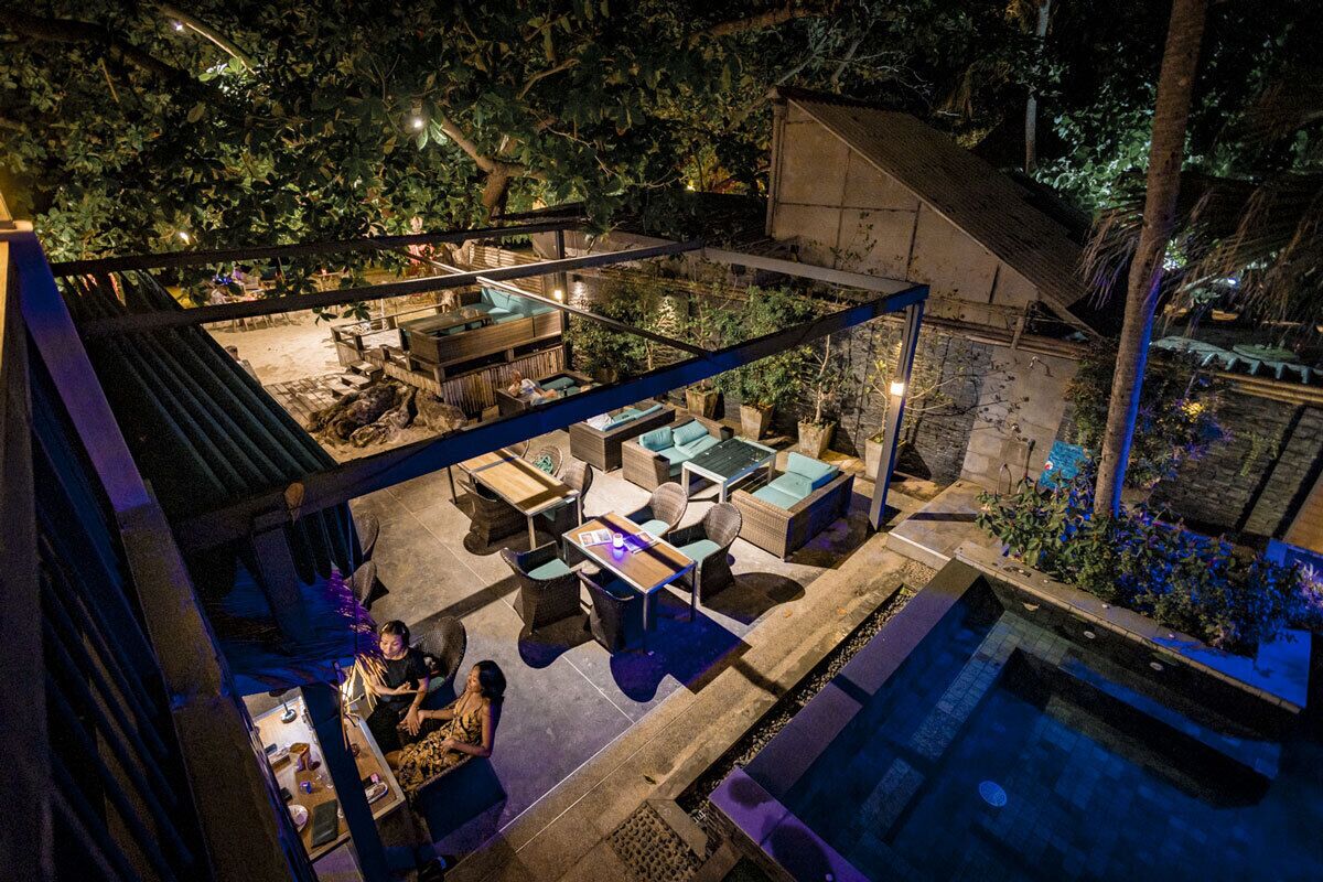 Un espace extérieur avec piscine, des chaises longues et un patio couvert.