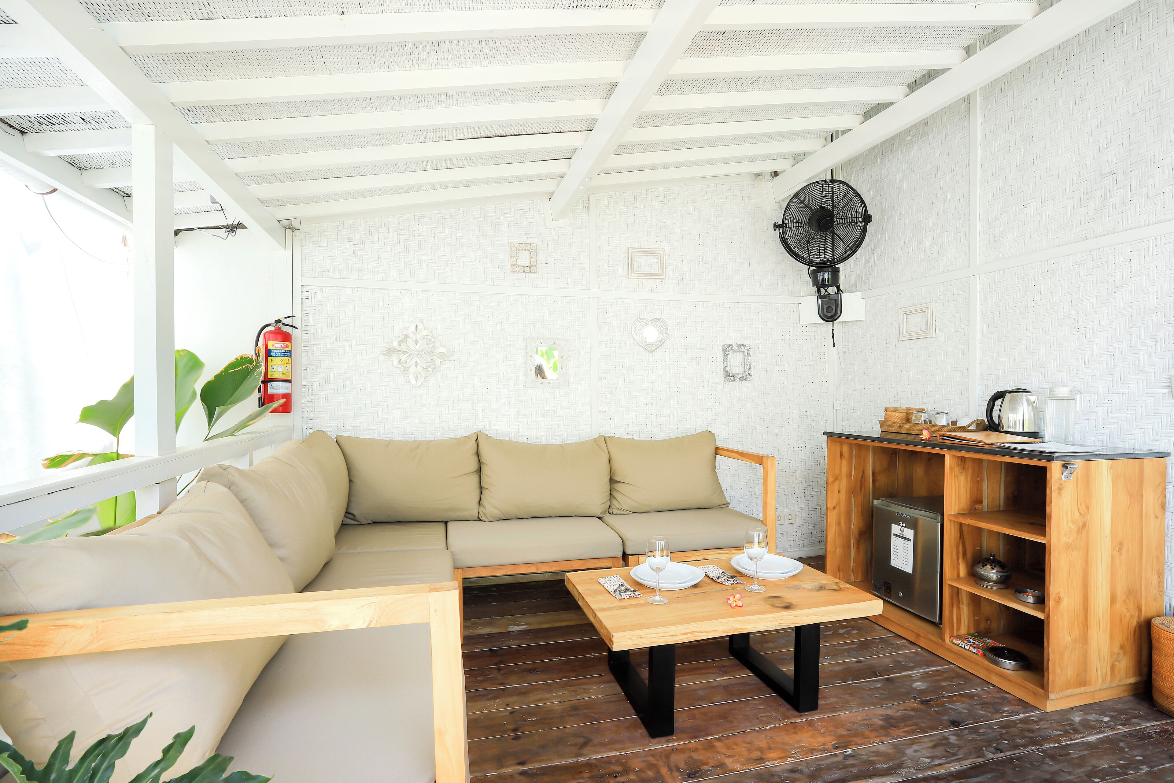 A cozy living area with a sofa, a wooden table, and a built-in kitchen unit.
