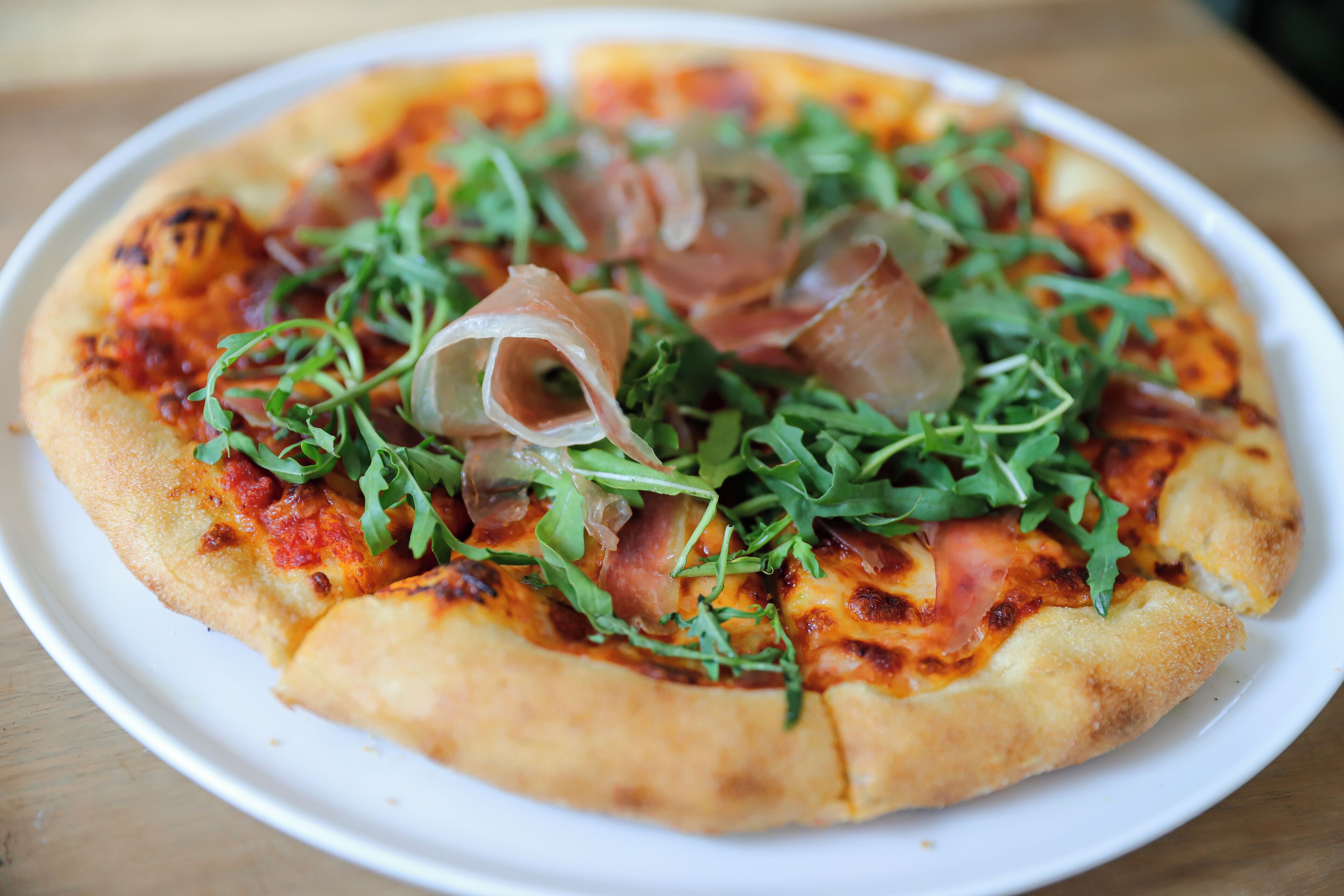 A pizza with toppings on a white plate.