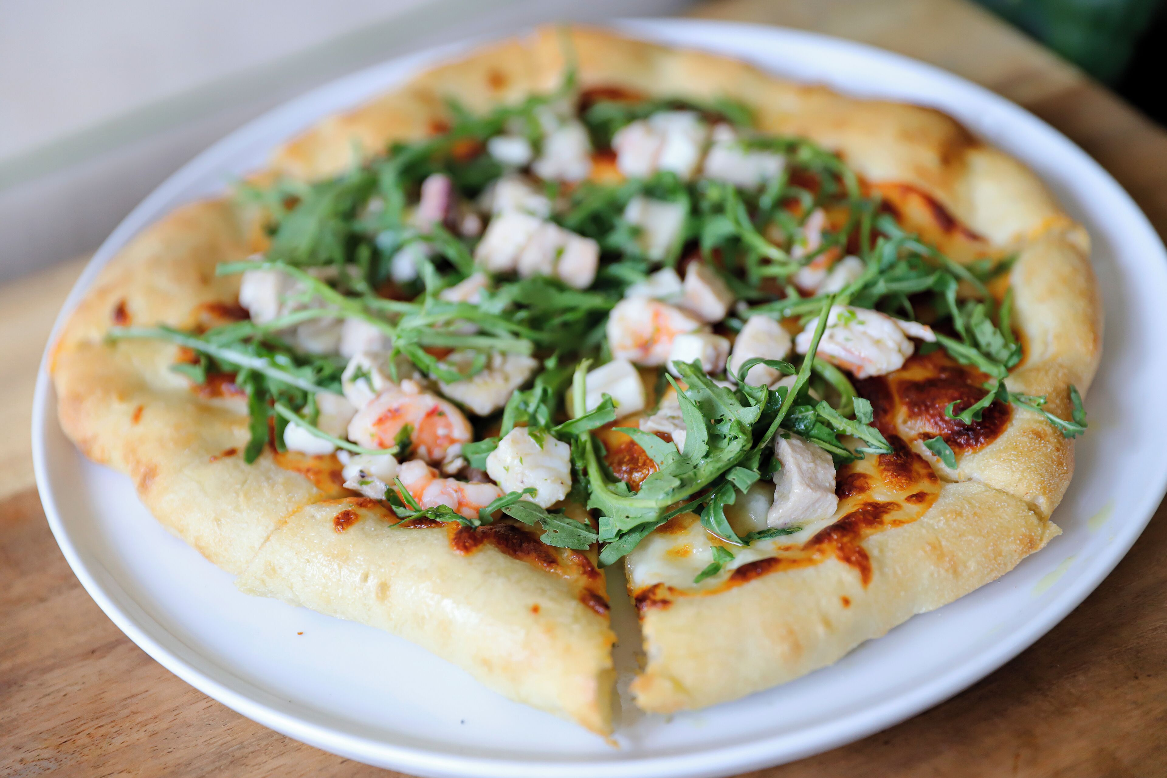 A pizza with toppings on a white plate.