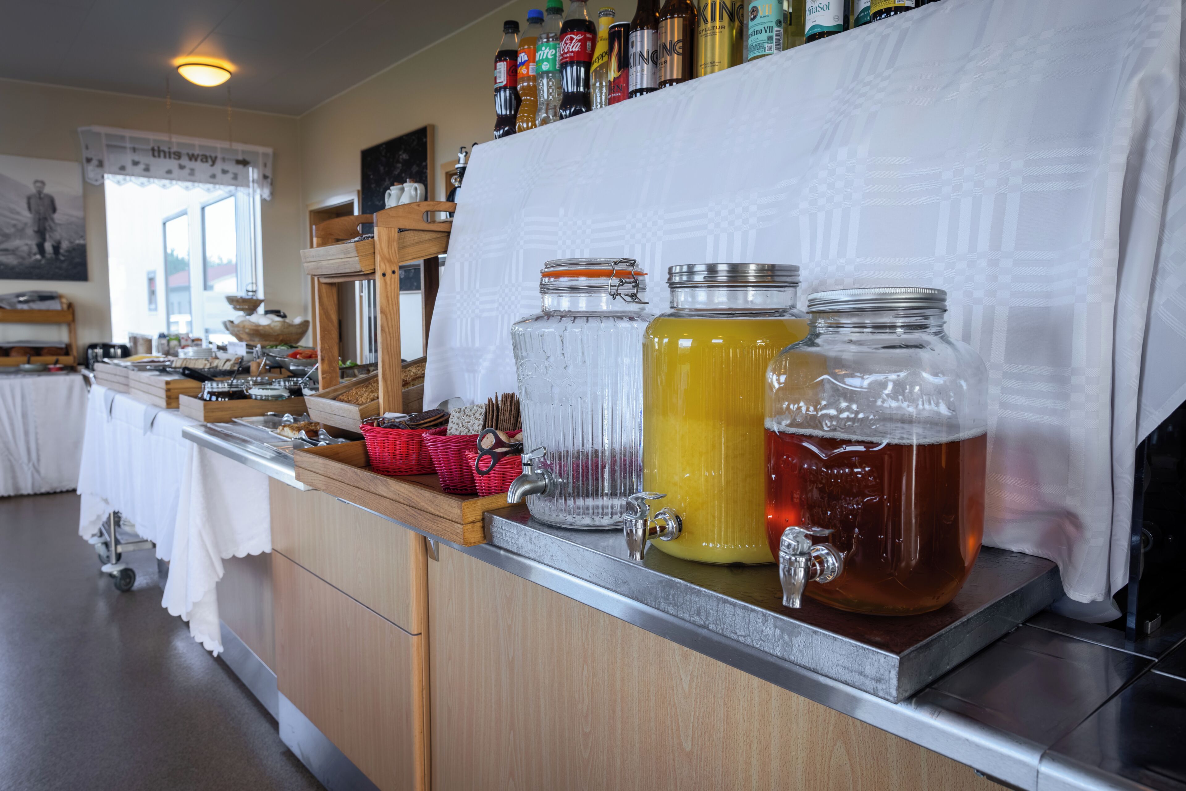 A bar area with various beverages, a coffee machine, and a buffet setup.